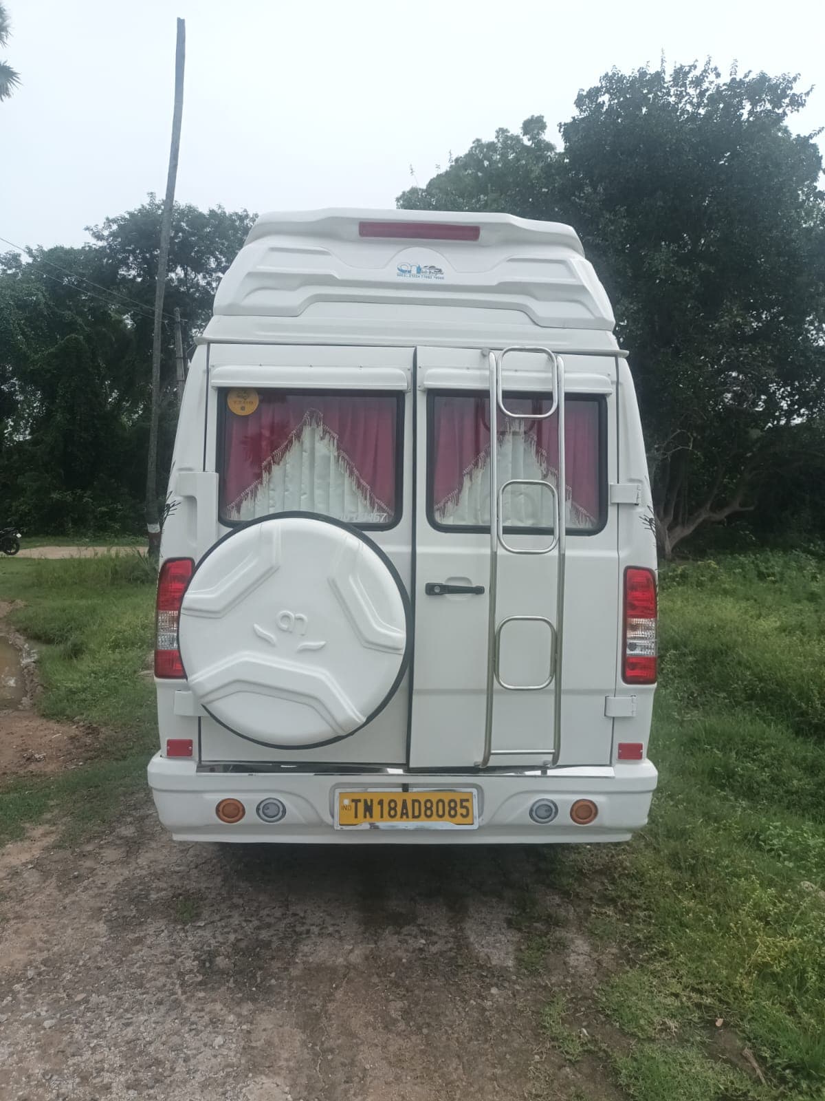 White Tempo Traveller rear view with boarding ladder and spare wheel