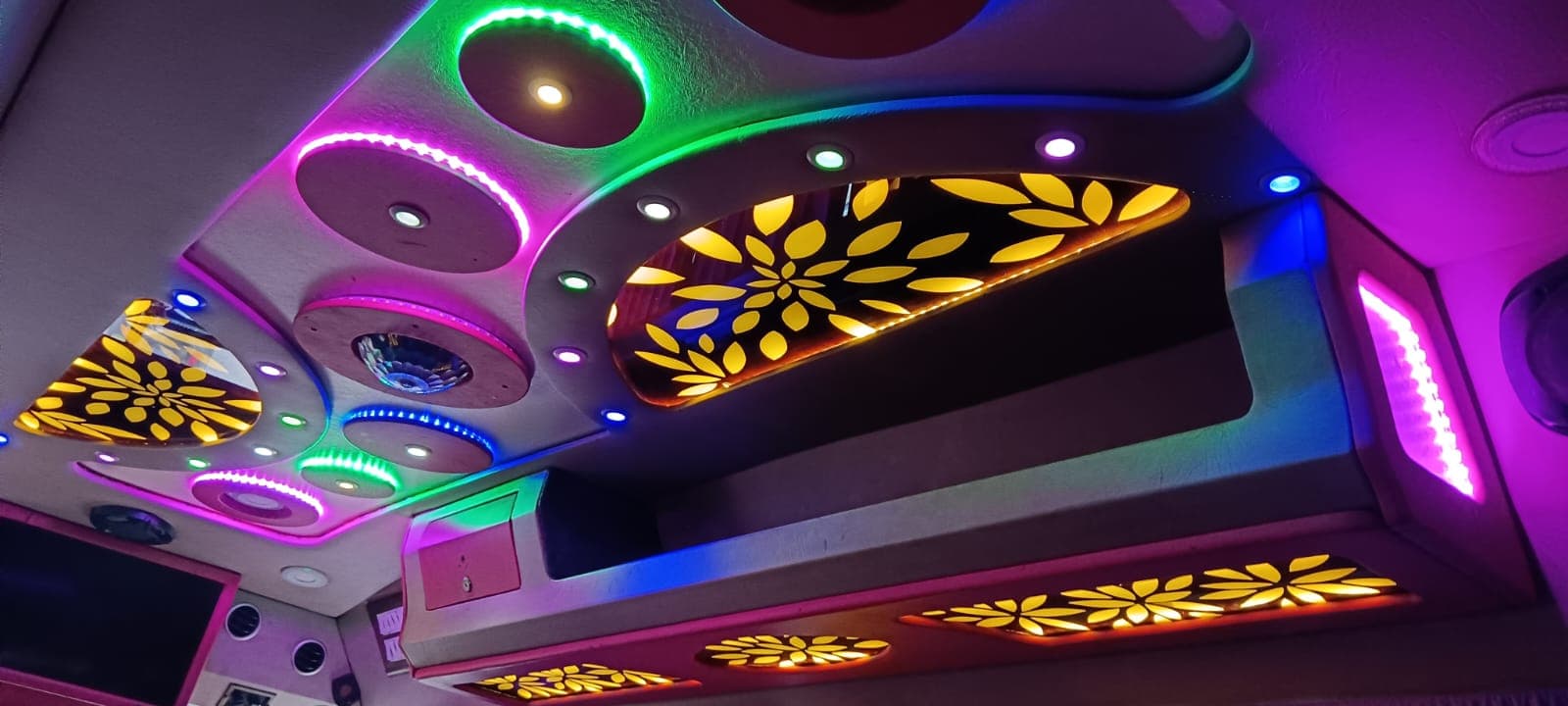 Tempo Traveller ceiling with colourful LED party lighting and floral cut-out panels