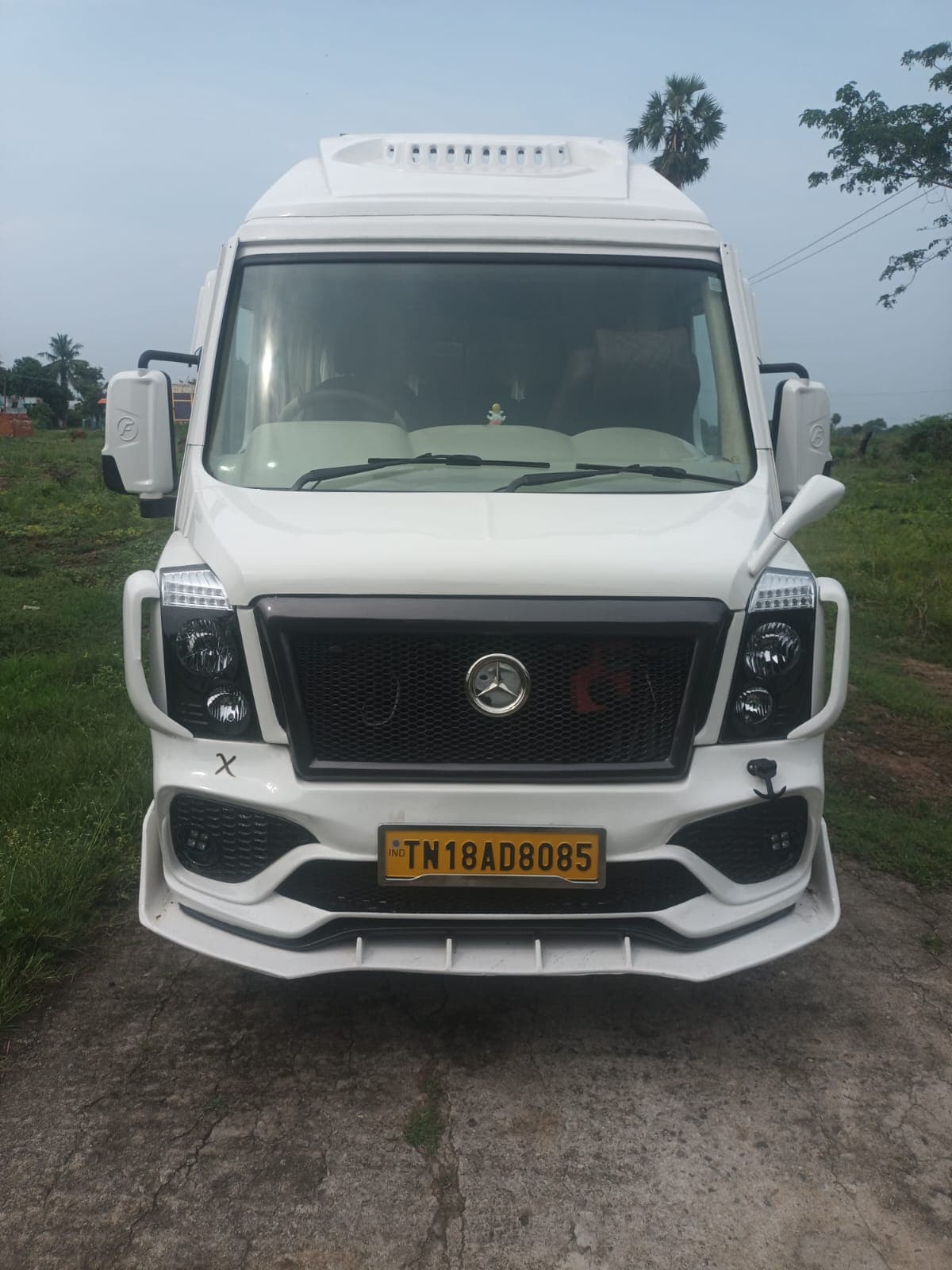 White Force Tempo Traveller parked in an open field, front view